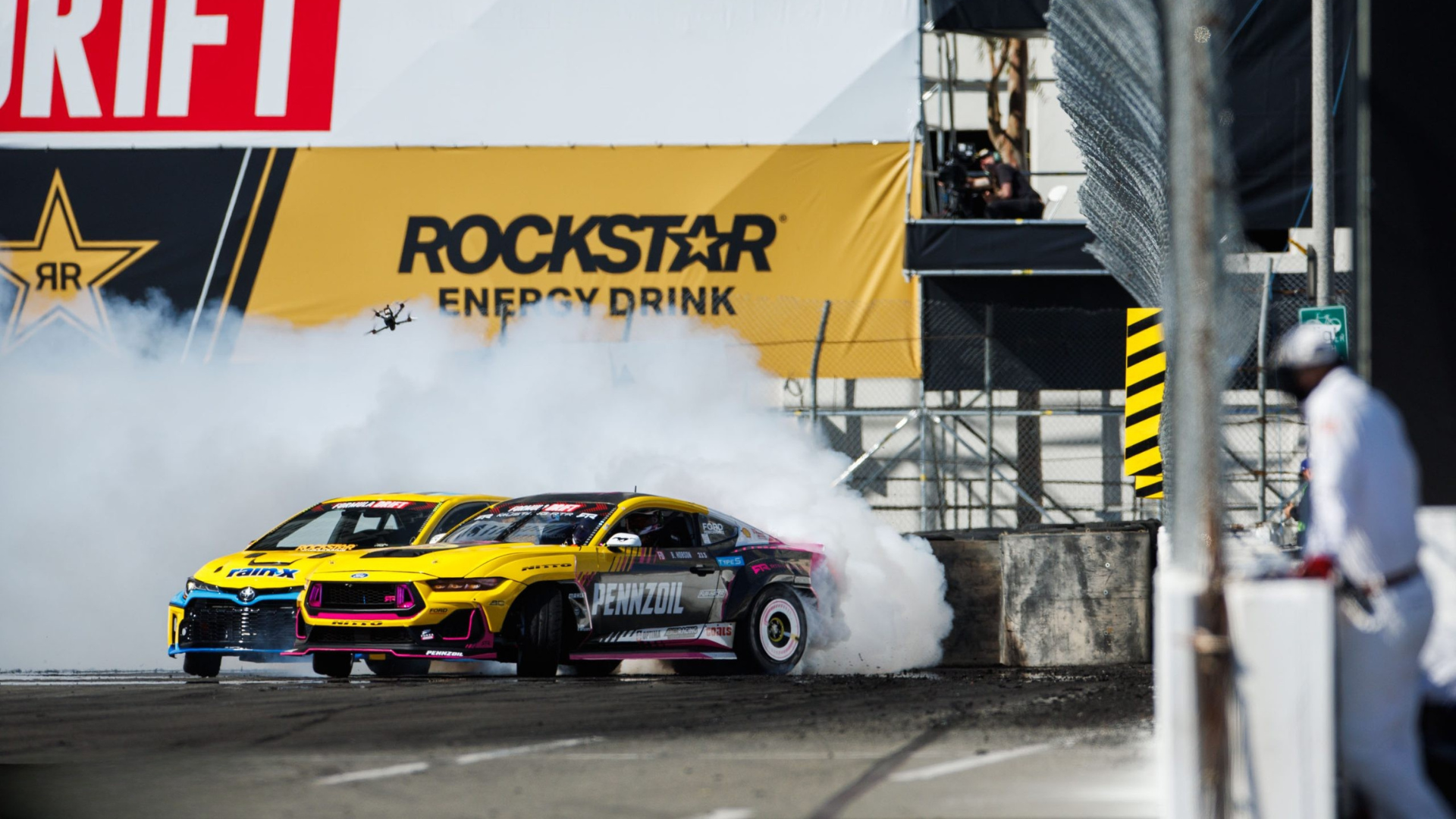 Official car drifting with visible branding and smoke on the circuit